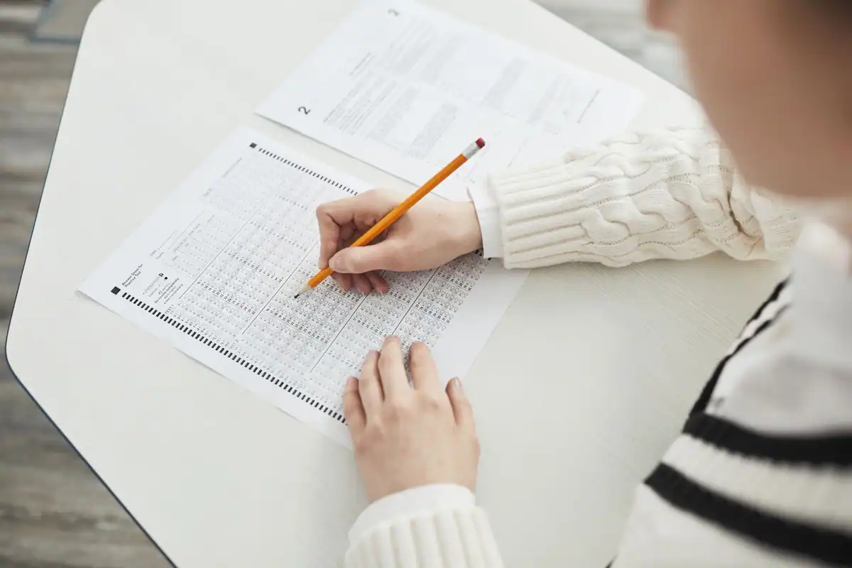 Candidată care completează grila de răspunsuri la examenul de admitere în sală
