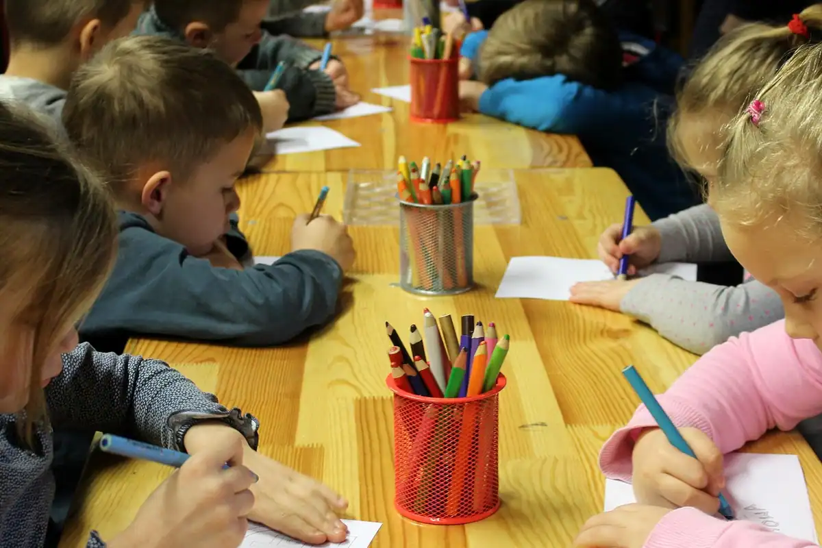 Mână care completează un formular, lângă bancnote și monede
