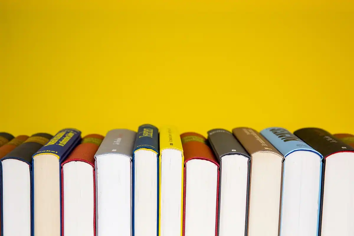 Stivă de cărți așezate pe un raft de bibliotecă, pentru studiu
