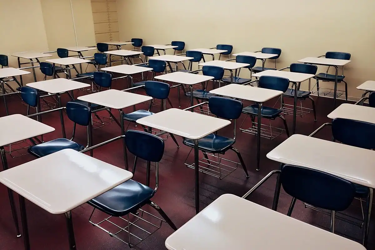 Sală de curs goală, cu rânduri de bănci care așteaptă studenții admiși