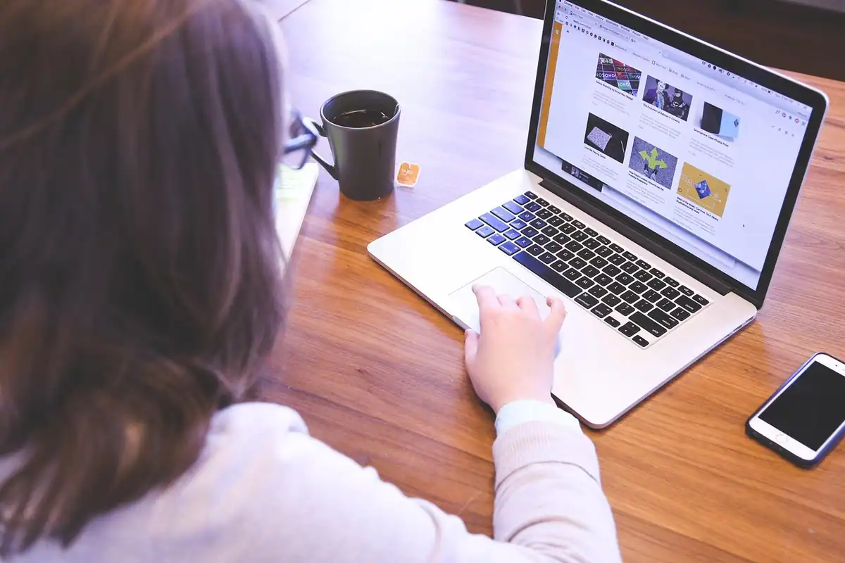 Tânără care lucrează la laptop, exersând competențele digitale la birou