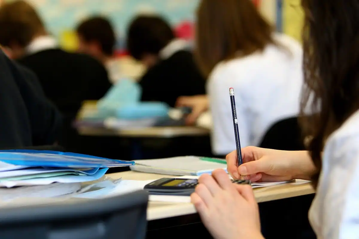 Elevi care rezolvă subiectele unei simulări de examen în sala de clasă