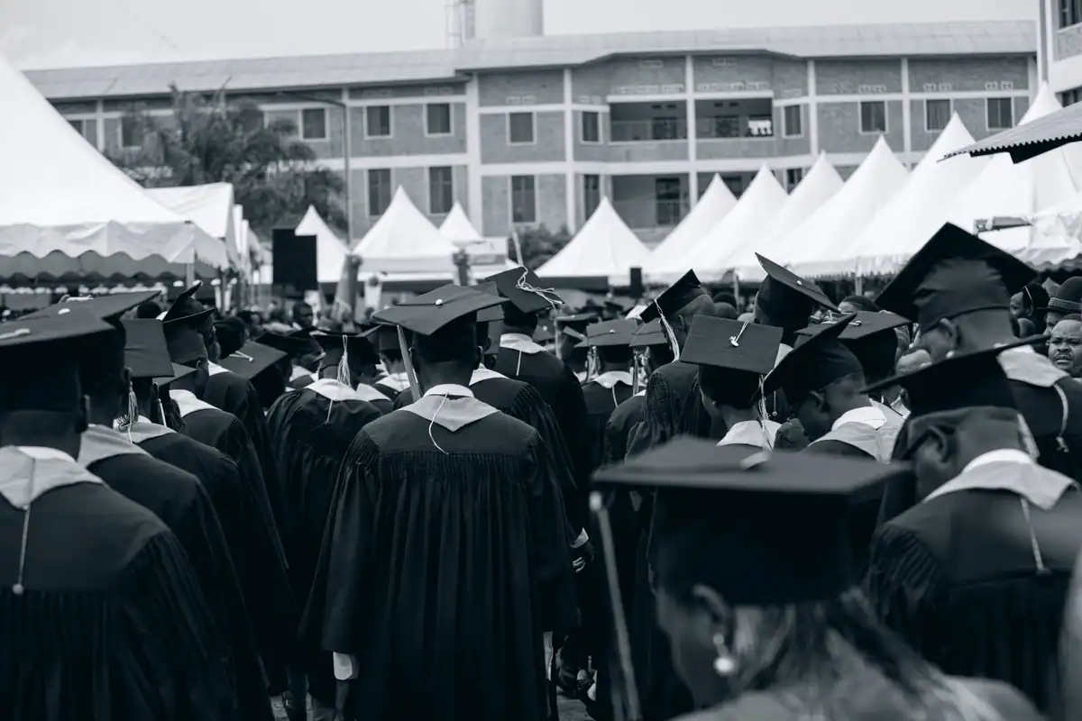 Absolvenți în robe și tocuri la ceremonia de absolvire în aer liber