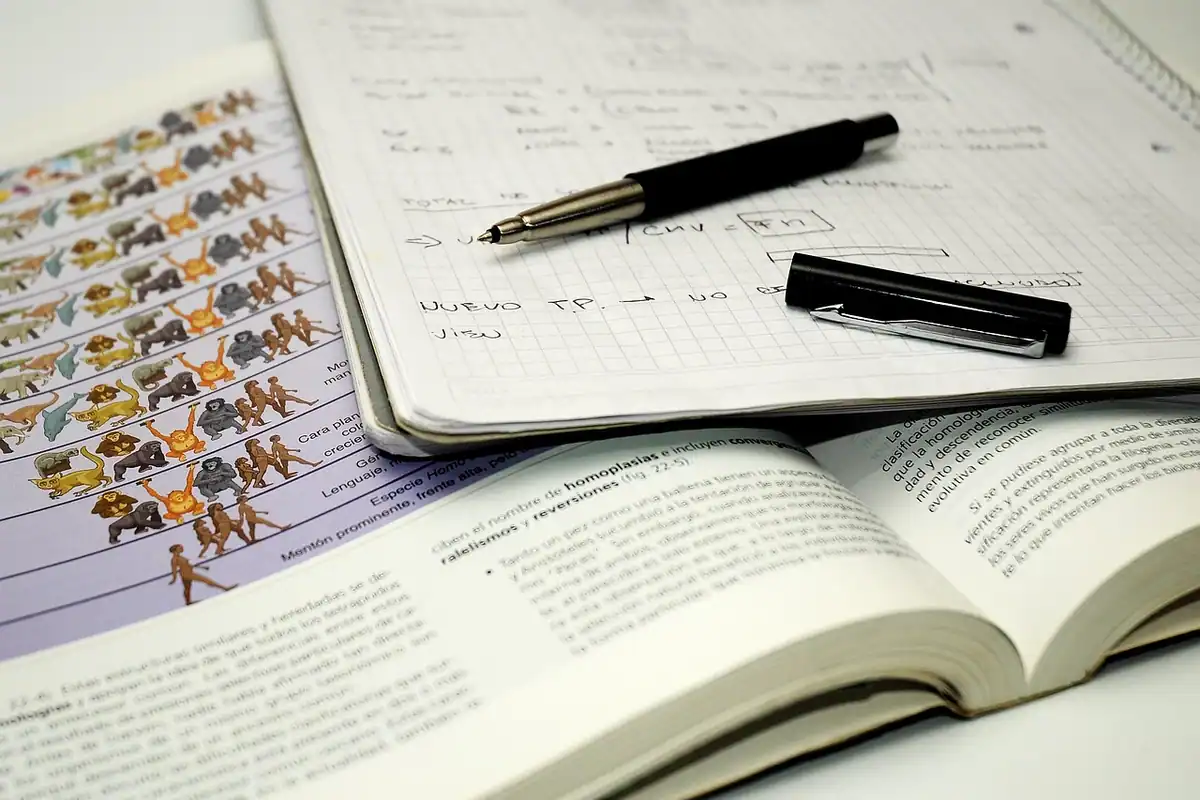 Student care învață din notițe de biologie, concentrat la masă